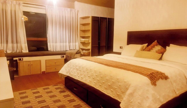 A retreat nestled among mountain peaks and crystal-clear waters, with views of the waterfall, mountains, and the river.